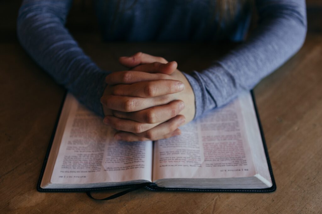 hombre orando con una biblia